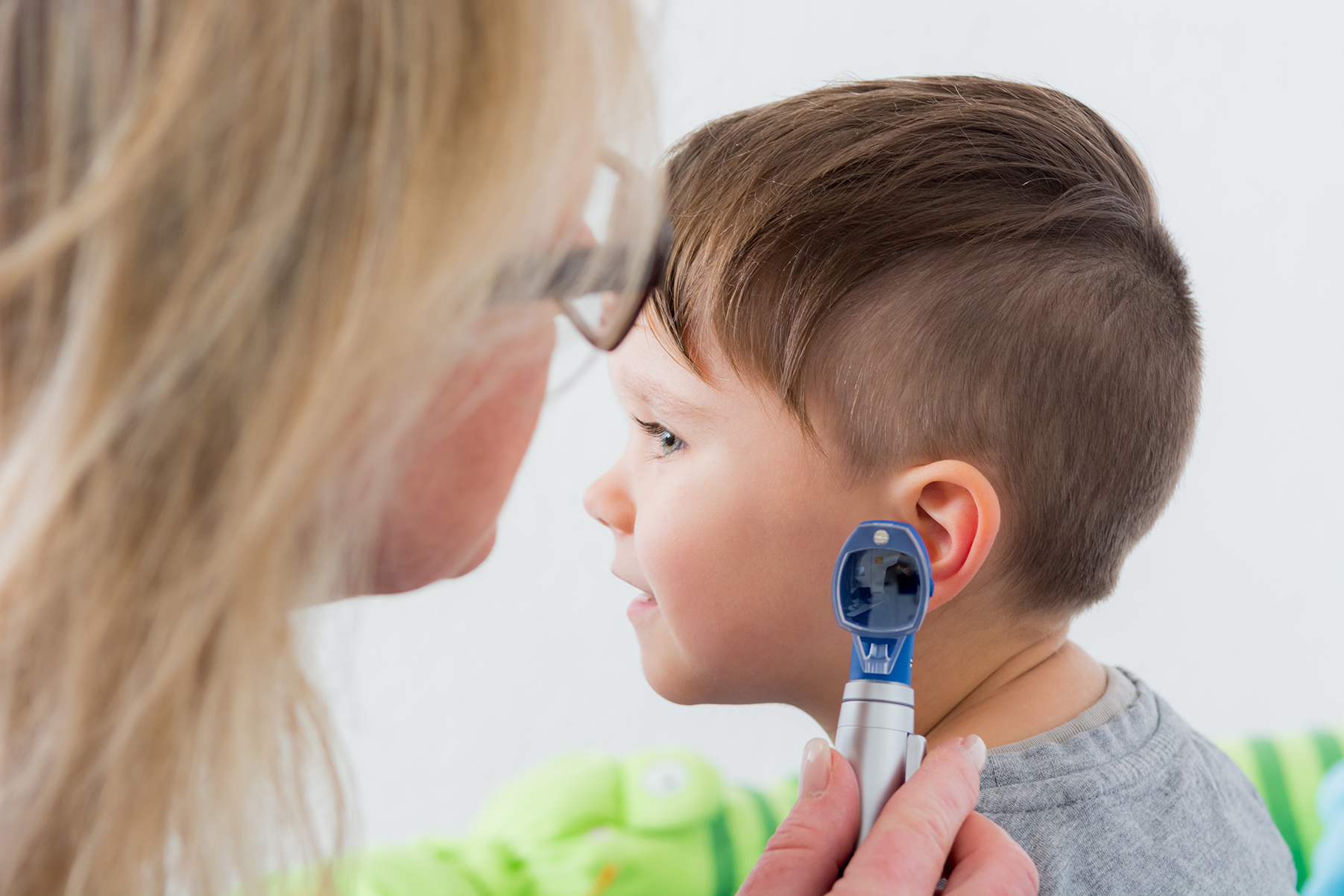 Eine Ärztin untersucht das Ohr eines Kleinkinds
