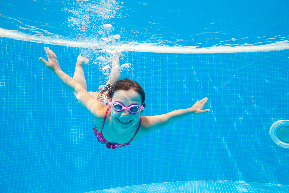 Kind taucht in einem Schwimmbecken.